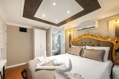 a bedroom with a large white bed with a gold frame at Azalea Mansion Oldcity in Istanbul