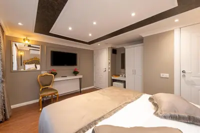 a bedroom with a large bed and a desk at Azalea Mansion Oldcity in Istanbul