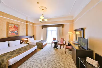 a hotel room with a bed and a desk and a television at Legacy Ottoman Hotel Istanbul Old City in Istanbul