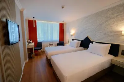 a hotel room with two beds and a flat screen tv at Dedeman Istanbul in Istanbul