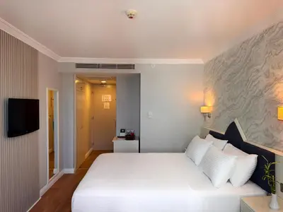 a bedroom with a white bed and a tv at Dedeman Istanbul in Istanbul