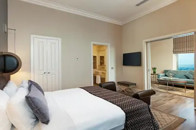 a bedroom with a large bed and a living room at Titanic Business Kartal in Istanbul
