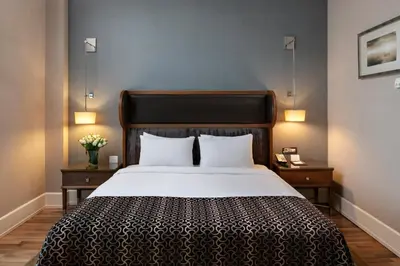 a bedroom with a large bed with two night stands and lamps at Titanic Business Kartal in Istanbul