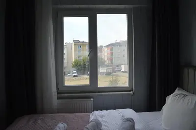 a bedroom with a window and a bed with white sheets at Classic Suite AA7 in Esenyurt