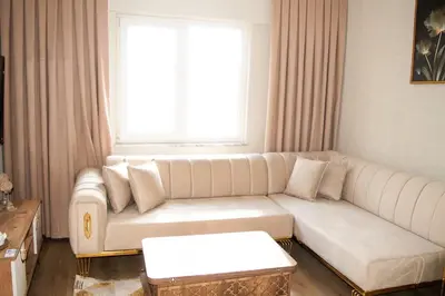 a living room with a white couch and a window at Two Bedroom King Suite TH30 in Esenyurt
