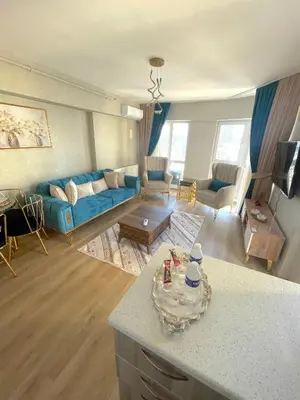 a living room with a blue couch and a table at King Suite AN33 in Esenyurt