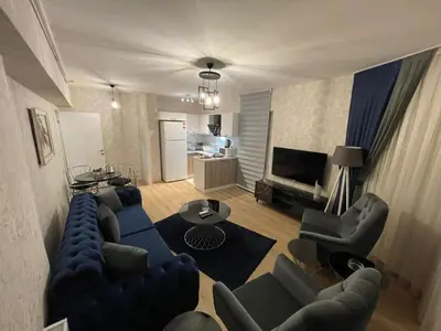 a living room with a couch and chairs and a television at King Suite MS5 in Esenyurt