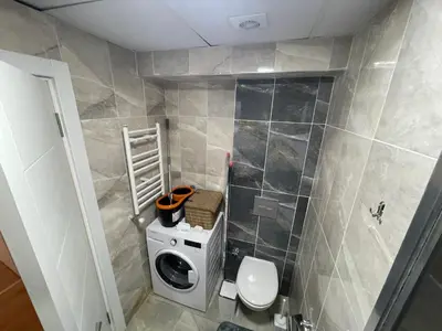 a bathroom with a toilet and a washing machine at King Suite TC1 in Esenyurt