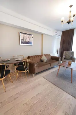 a living room with a brown couch and a table at King Suite AM2 in Esenyurt