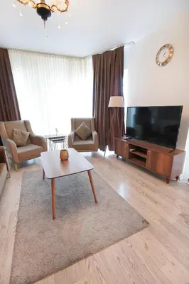 a living room with a large television and a coffee table at King Suite AM2 in Esenyurt