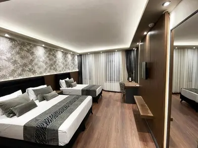 a hotel room with two beds and a television at GRAND ÜSKÜDAR OTEL in Istanbul