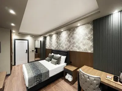 a hotel room with a bed and a desk and a table at GRAND ÜSKÜDAR OTEL in Istanbul