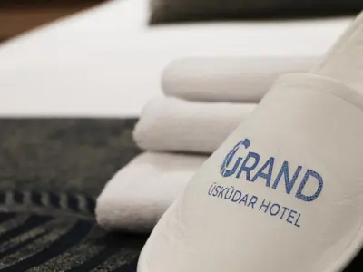 a stack of white towels with the words grand australian hotel at GRAND ÜSKÜDAR OTEL in Istanbul