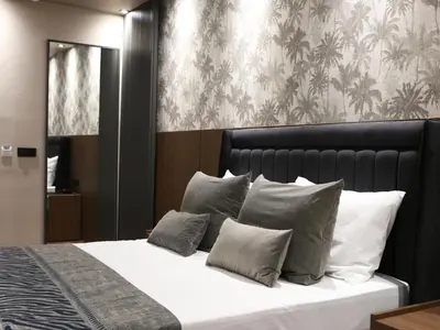 a bedroom with a bed with white sheets and gray pillows at GRAND ÜSKÜDAR OTEL in Istanbul