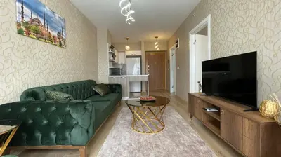 a living room with a green couch and a flat screen tv at Luxe Suite AI3 in Esenyurt