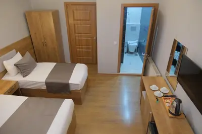 a hotel room with two beds and a mirror at Adamantides Hotel in Istanbul