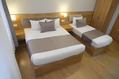 two beds in a small room with wooden floors at Adamantides Hotel in Istanbul