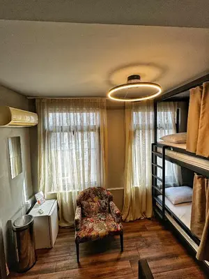 a bedroom with two bunk beds and a chair at Nomad Hostel Karaköy in Istanbul