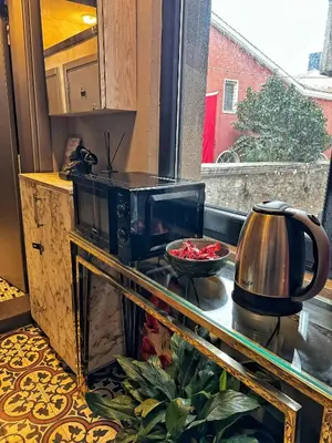 a kitchen with a microwave and a bowl of food at Nomad Hostel Karaköy in Istanbul
