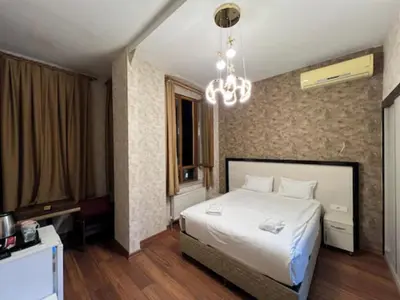 a bedroom with a white bed and a chandelier at Gran Brn Hotel Taksim in Istanbul
