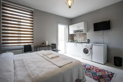 a bedroom with a bed and a kitchen with a washing machine at Zelya İstanbul flats in Istanbul