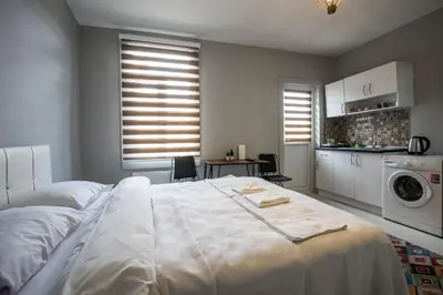 a bedroom with a large white bed and a kitchen at Zelya İstanbul flats in Istanbul