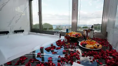 a table with a plate of food and flowers on it at AURA MARINA HOTEL in Istanbul