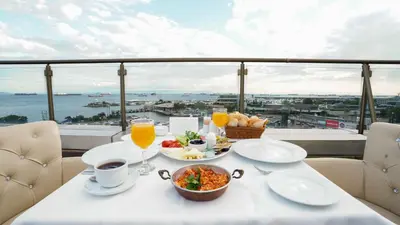 a table with food and drinks on a balcony at AURA MARINA HOTEL in Istanbul