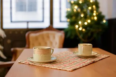 two coffee cups sitting on a table with a christmas tree at Aleksandr Pera Hotel in Istanbul