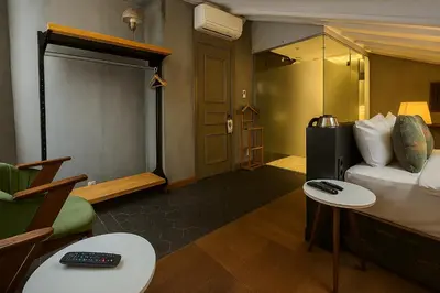 a room with a bed and a couch and tables at Aleksandr Pera Hotel in Istanbul
