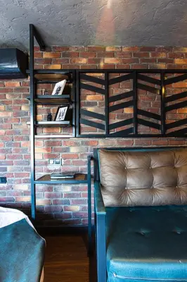 a couch sitting next to a brick wall with shelves at Mansion Gorki in Istanbul