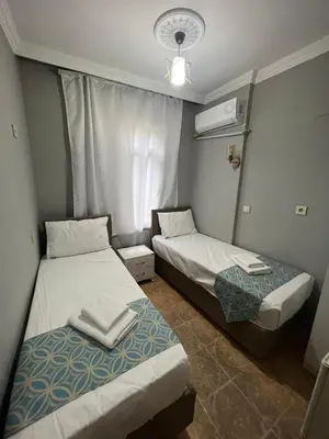 two beds in a small room with a window at GRAND Deniz Hotel in Istanbul