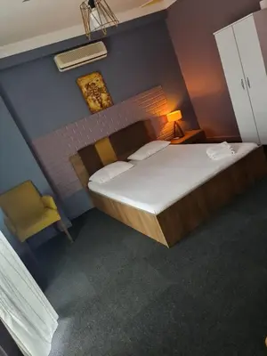 a small bedroom with a large bed and a chair at Retro Suites in Istanbul