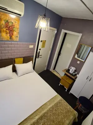 a bedroom with a white bed and a table and a door at Retro Suites in Istanbul