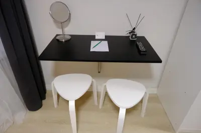 a black table with two white chairs and a mirror at Cactus Suites in Istanbul