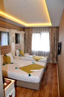a hotel room with three beds and a window at Sun Comfort Hotel in Istanbul