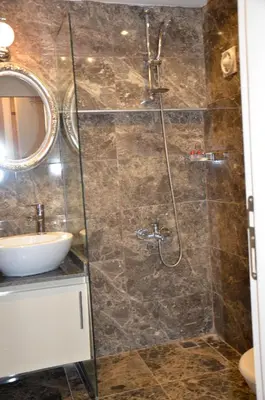 a bathroom with a shower with a sink and a mirror at Sun Comfort Hotel in Istanbul