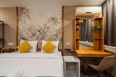 a bedroom with a bed with yellow pillows and a desk at Sayeban Gold Hotel in Istanbul