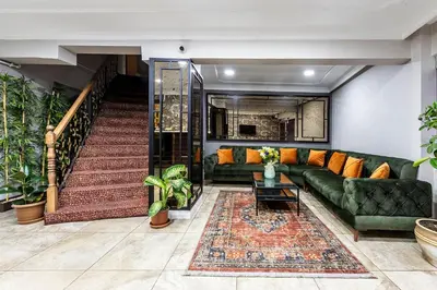 a living room with a green couch and a staircase at Kadirga Antik Hotel - Sultanahmet in Istanbul