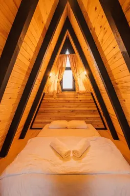 two beds in a wooden room with a window at KARMATTE BUNGALOW in Kartepe