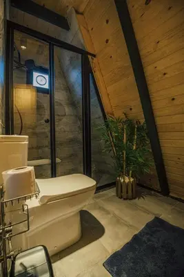 a bathroom with a toilet in front of a window at KARMATTE BUNGALOW in Kartepe
