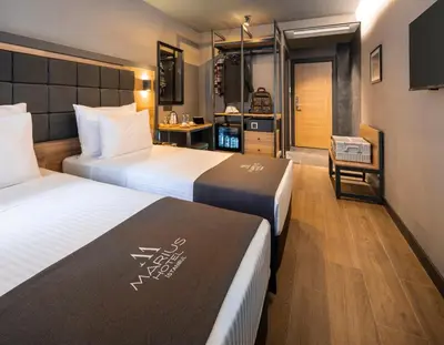 a hotel room with two beds and a television at Marius Hotel in Istanbul