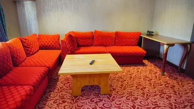 a living room with a red couch and a wooden table at Vois Hotel Atasehir & SPA in Istanbul