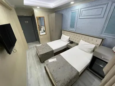 a small room with two beds and a television at Grand Kybele Hotel in Istanbul
