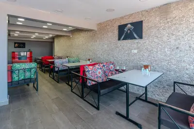 a dining room with tables and chairs and a brick wall at Airport Black Sea Hotel & Restaurant in Arnavutköy