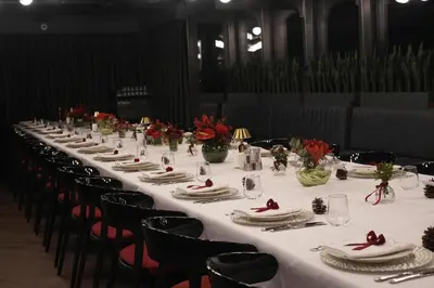 a long table with white table cloth and red flowers on it at Wish More Hotel Şişli in Istanbul