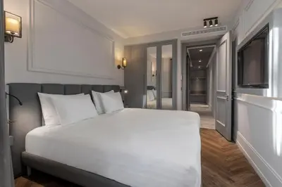 a bedroom with a large white bed and a television at Wish More Hotel Şişli in Istanbul
