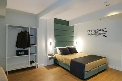 a bedroom with a bed with a green headboard at AXU AIRPORT HOTEL in Arnavutköy