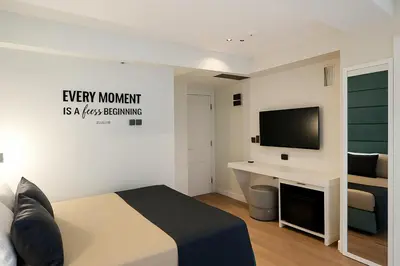 a bedroom with a bed and a desk with a television at AXU AIRPORT HOTEL in Arnavutköy