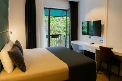 a hotel room with a bed and a desk and a window at AXU AIRPORT HOTEL in Arnavutköy